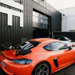 An orange sports car parked in front of a building