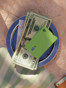 Podróżnik wyciąga gotówkę z bankomatu na tle wieży Eiffla w Paryżu