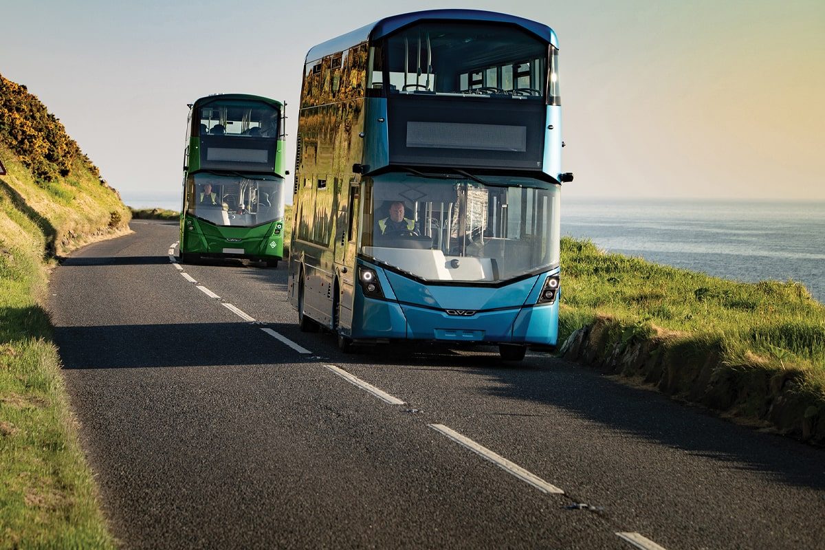 Czerwony elektryczny autobus podłączony do ładowarki na stacji z migającymi światłami i ekranami