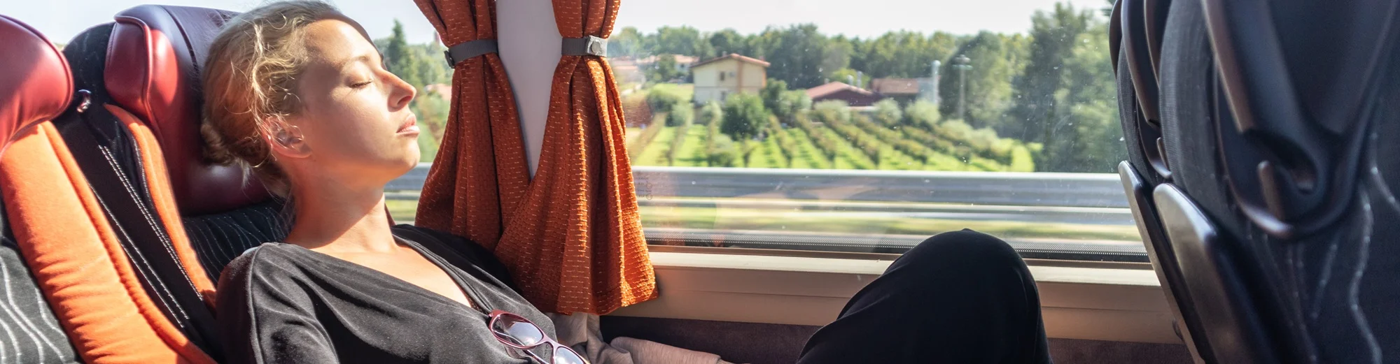 Grupa pasażerów rozmawia i śmieje się w środku zatłoczonego autobusu w dzień