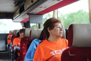 Autobus jedzie autostradą z pasażerami patrzącymi przez okna na rozległe pola i lasy